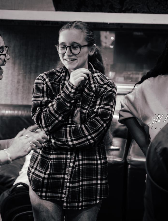 group of young women talk and laugh together whilst in a music workshop