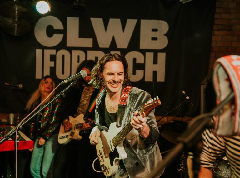 Close up shot of person playing the guitar at Clwb Ifor Bach.