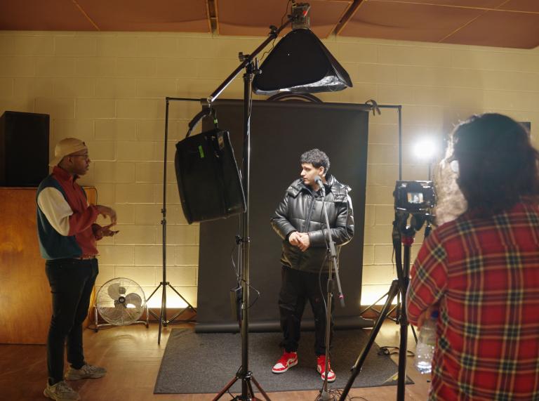 Medium shot of a musician standing in front of a camera on set