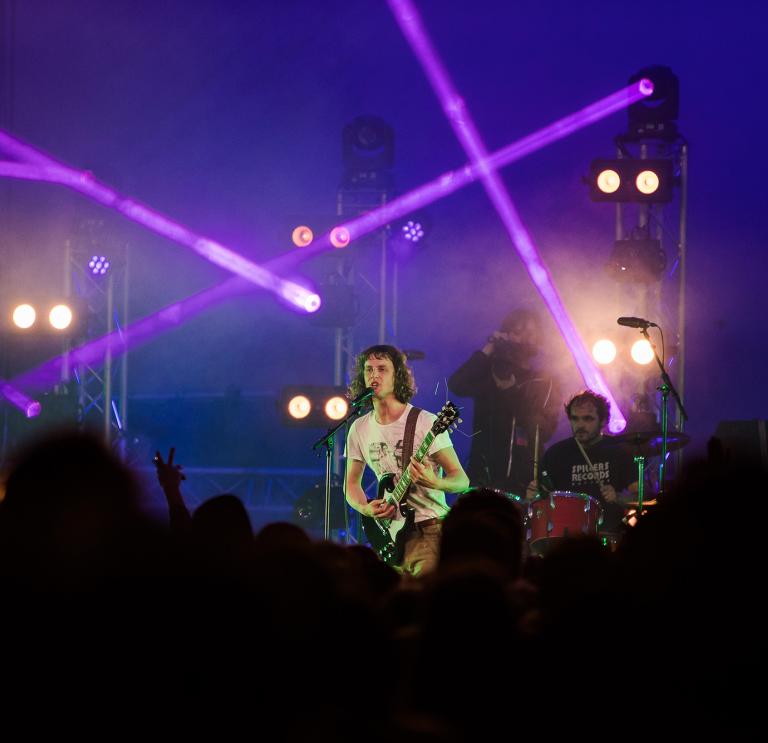 Shot of the lead singer from Buzzard Buzzard Buzzard, Tom performing on stage at Clwb Yn Y Castell (2021)