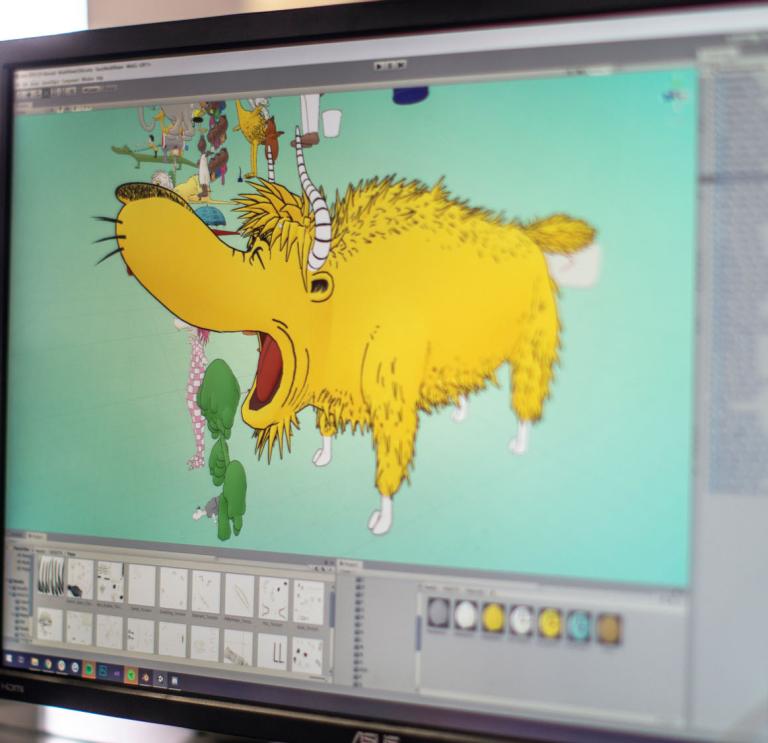 Computer screen with an artist drawing a yellow four-legged animal from Dr Seuss