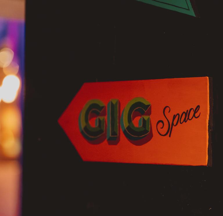 red sign with black writing saying 'GiG Space'