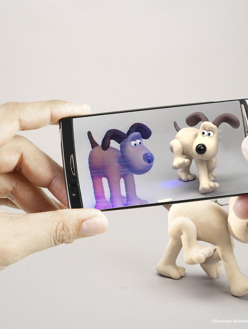 Close up of hands holding an iphone showcasing Gromit from Wallace Gromit