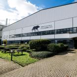 Exterior view of a film and TV studio, a large white building with  Black Wolf logo and a sign that says