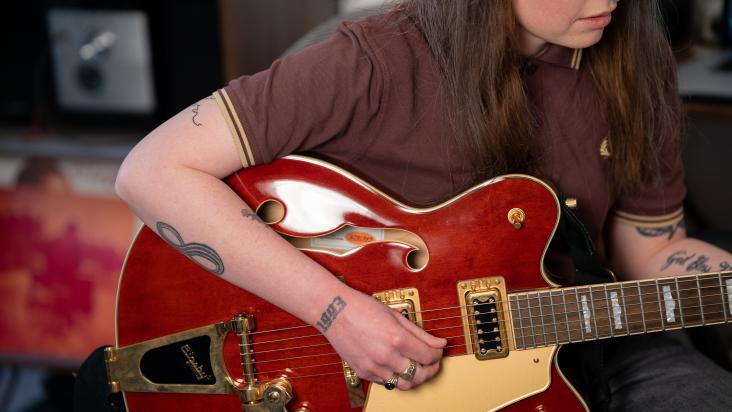 Close up shot of Nia Wyn playing a red semi-acoustic gretsch streamliner.